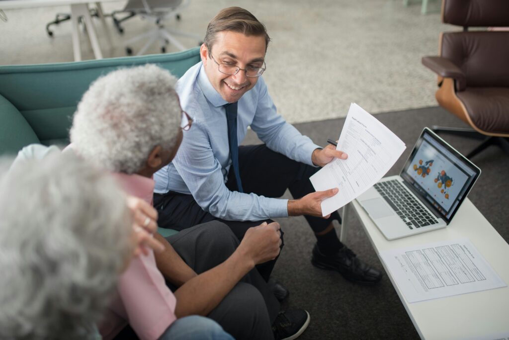 Professional tax advisor assisting an elderly man with financial documents.