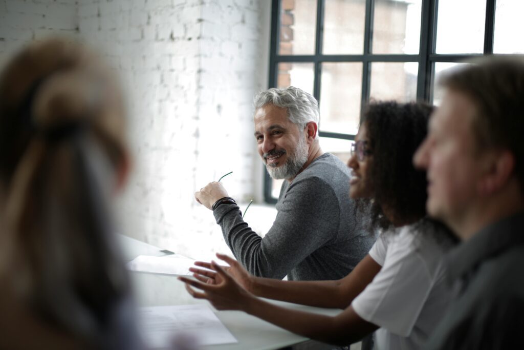 A group of people engaged in a discussion, symbolizing the complexities of understanding the Roth IRA 5-Year Rule.