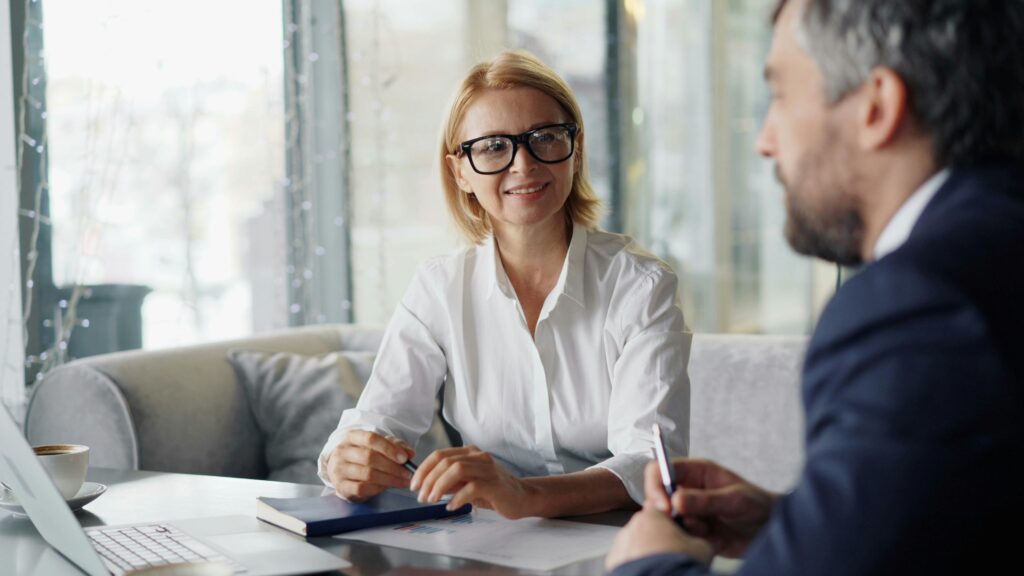 Image of two individuals conversing in an office setting.