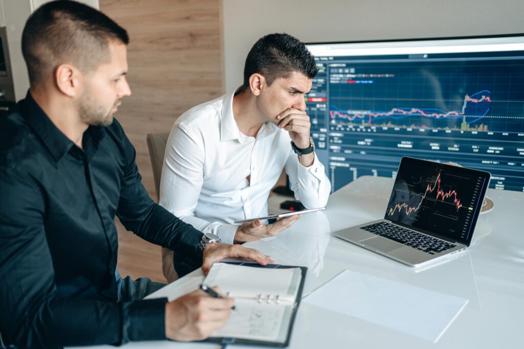 Investor reviewing a smartphone while analyzing declining investment performance.