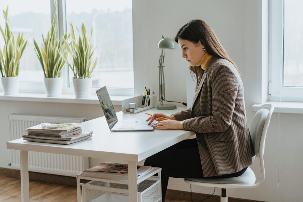 A woman working at her desk reviewing financial documents, representing the SECURE 2.0 retirement account changes taking effect in 2025.
