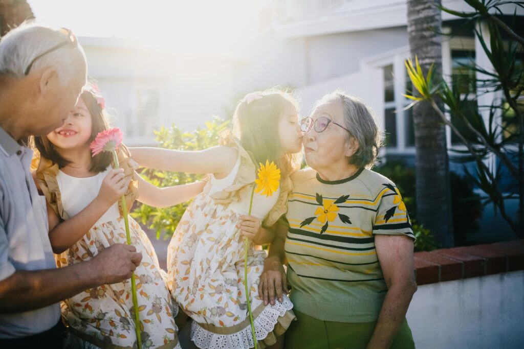 Grandchildren kissing their grandparents affectionately, symbolizing family love, legacy, and the importance of inheritance planning across generations.