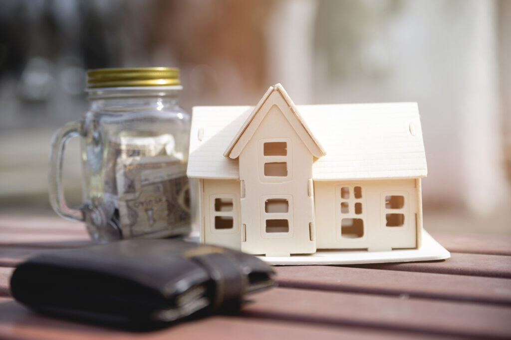 Image of a house and wallet beside each other to symbolize asset management.
