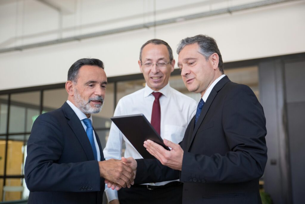 Businessmen reviewing digital tablet data during a meeting.