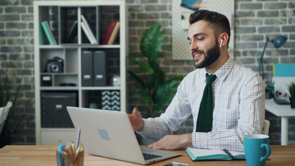 An office worker smiles while looking at a laptop screen, highlighting tax firm efficiency.